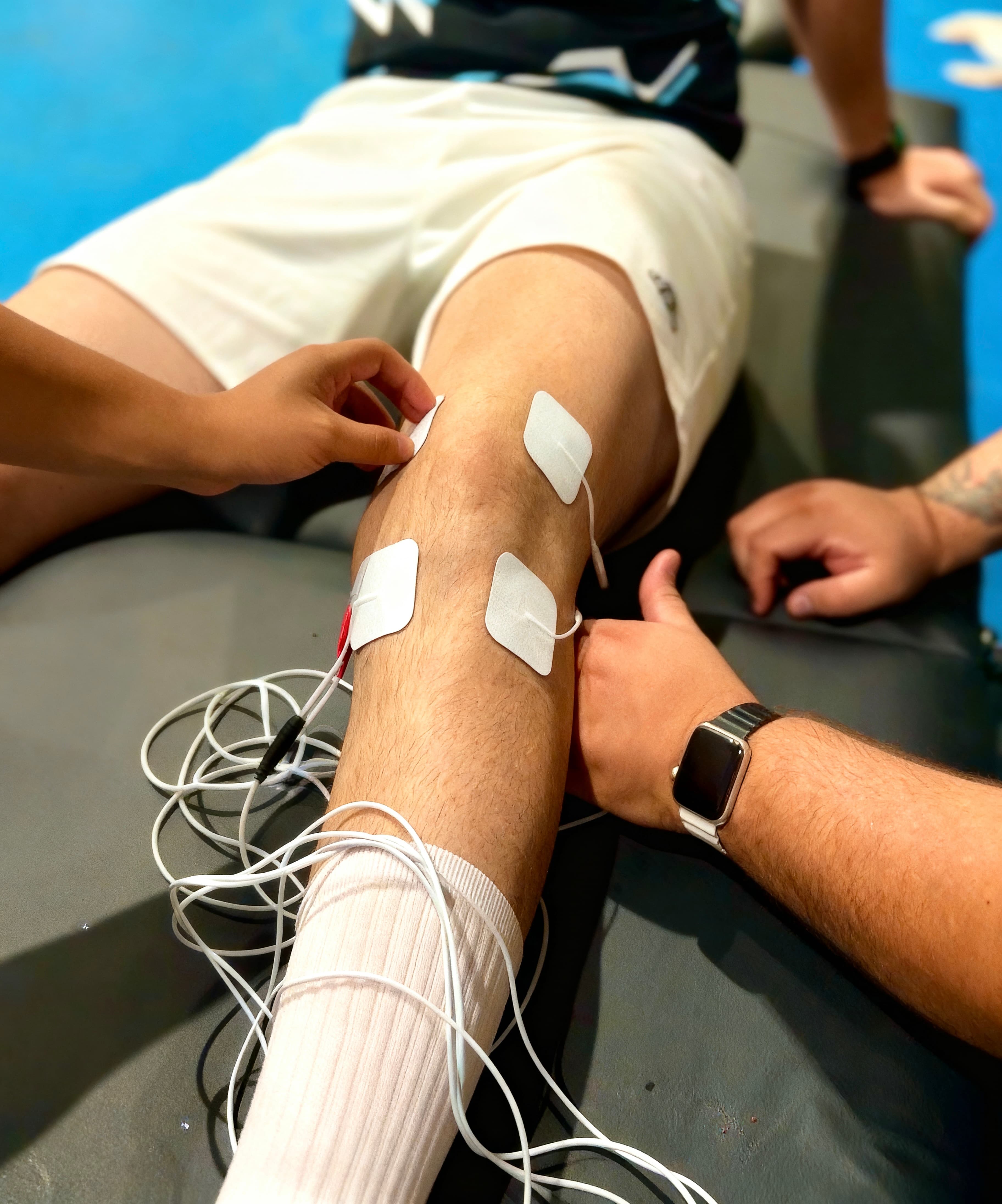 Fisioterapeuta aplicando eletroestimulação no joelho de um paciente